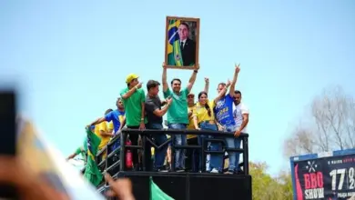 Flávio Bolsonaro se emociona durante comício e ergue retrato de Jair Bolsonaro