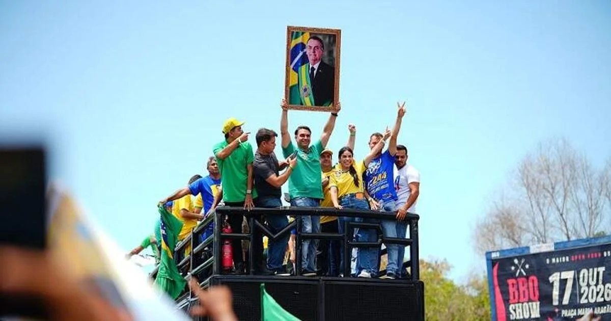 Flávio Bolsonaro se emociona durante comício e ergue retrato de Jair Bolsonaro